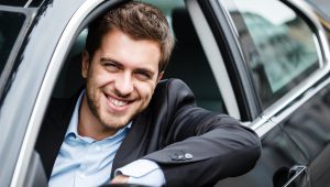 Mężczyzna w samochodzie z wypożyczalni aut korzystający z usługi car sharing
